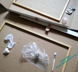 Two frames on the floor, being painted gold