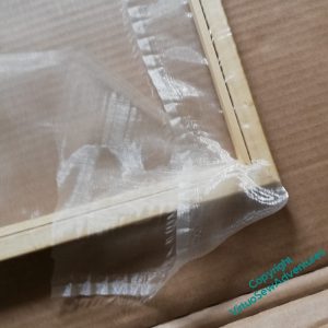 In the process of mounting a gauze overlay on a frame,