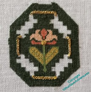 The honeysuckle motif, green background completed, and first element of the strapwork in place