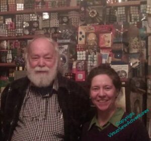 David Singmaster, elderly, white bearded, and me, barely up to his shoulder, against a wall of shelves in his library.