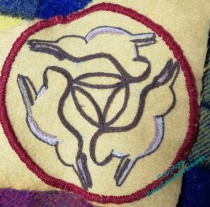 The Three Hares, still mainly in outline, but now with a ring of red blanket stitch