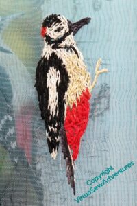 Woodpecker, as finished as I need it to be until I'm assembling the panels, with the source photo showing through the gauze.
