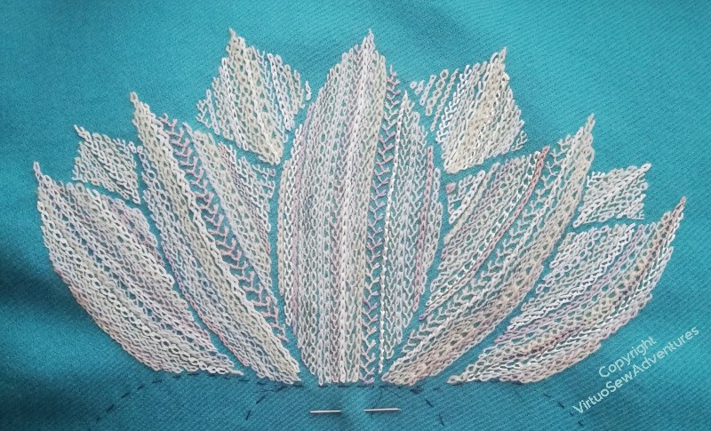 The first lotus flower done, all in cream and white and pink line stitches on turquoise tweed.