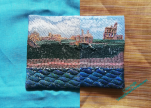An image showing the Tynemouth Priory embroidery against two fabrics, one turquoise linen, one amber striped silk.