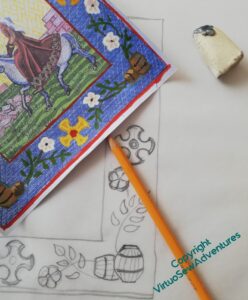 Aethelflaed's border in progress again. You can see a draft on tracing paper, a yellow pencil, and eraser, and a corner of one of my painted design ideas