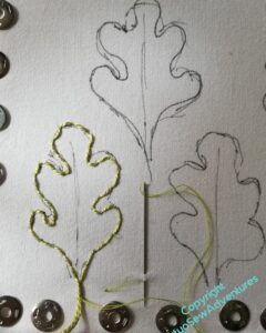 First oak leaf outlined in pearl cotton, couched around the shape.