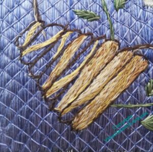 First skep, tilting to the left, partly stitched in greyish yellows and creams.